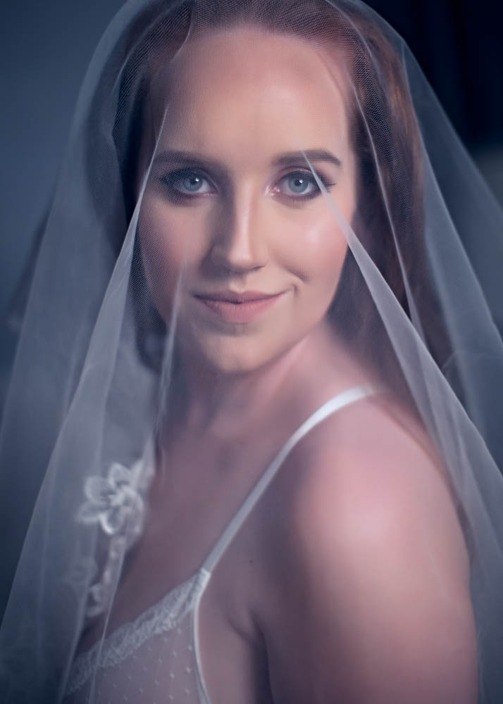 A beautiful bride in a veil posing for a photo.