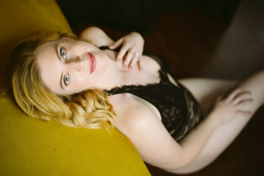 A woman lounging on a couch during a Northern Virginia boudoir photography session.