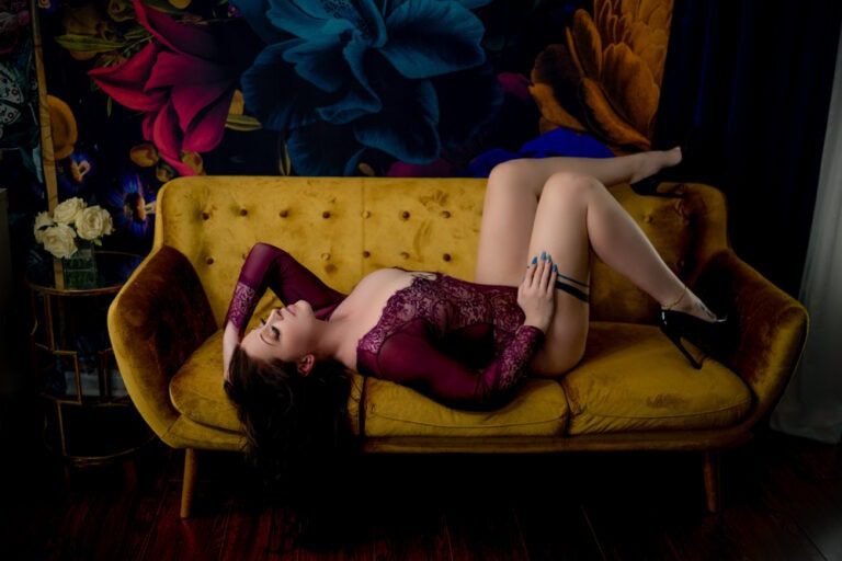 A woman in lingerie laying on a yellow couch.