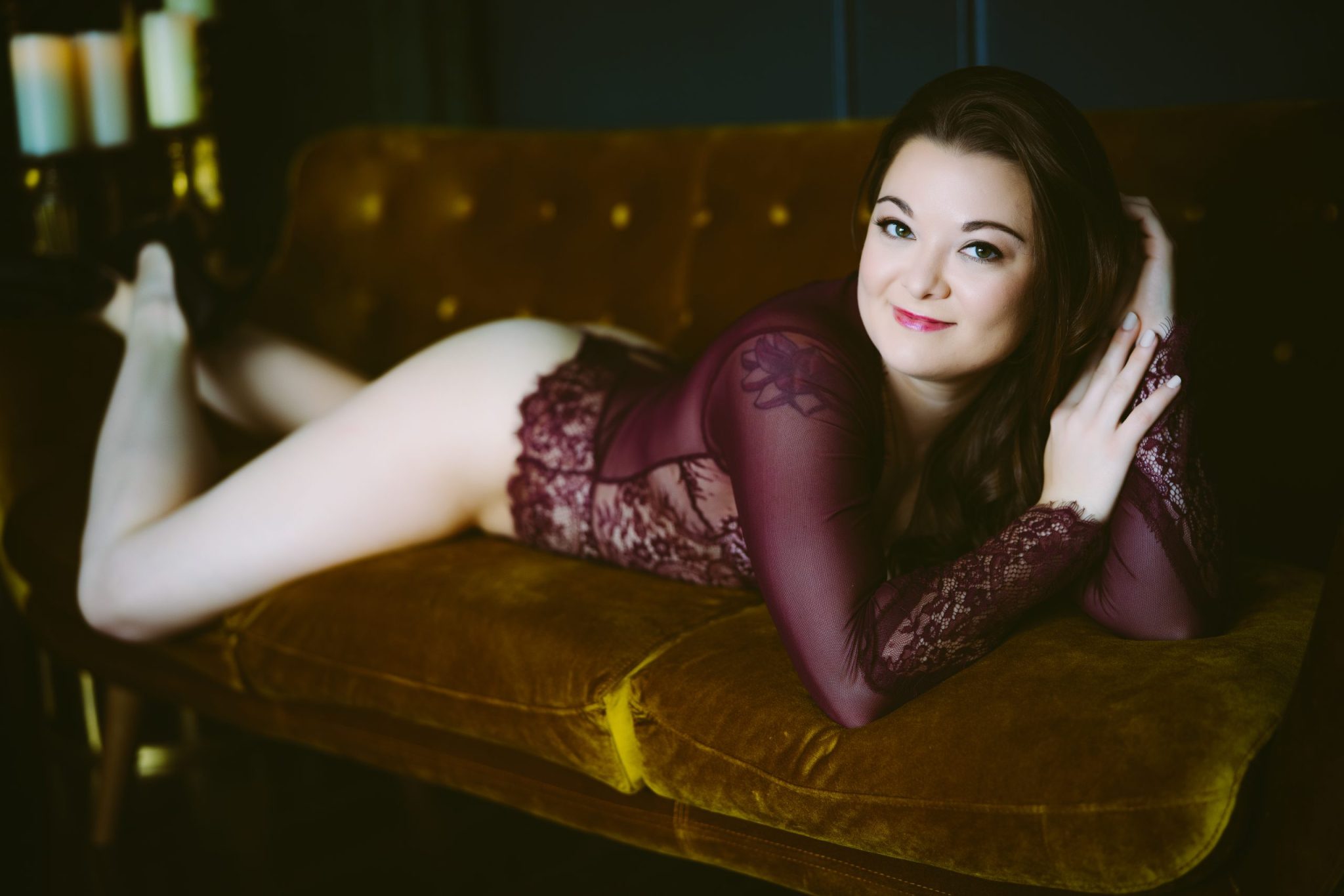A woman lounging on a couch in lace lingerie for Northern Virginia Boudoir Photography.