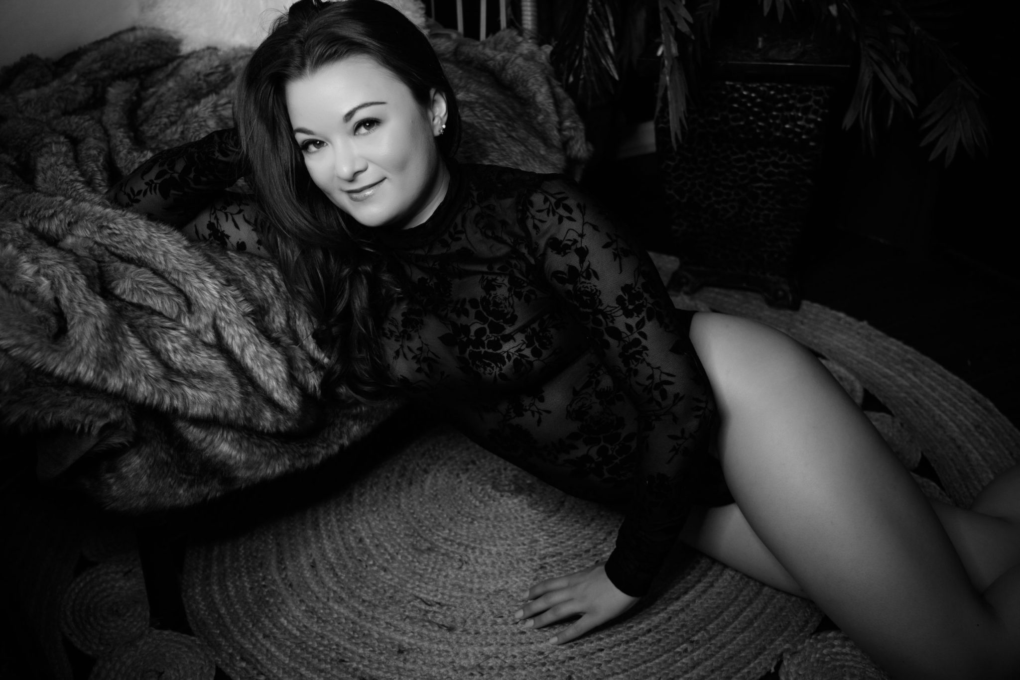 A woman in black and white laying on a rug in Northern Virginia Boudoir Photography.