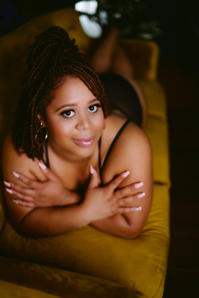 A woman lounging on a yellow couch during a Northern Virginia boudoir photography session.